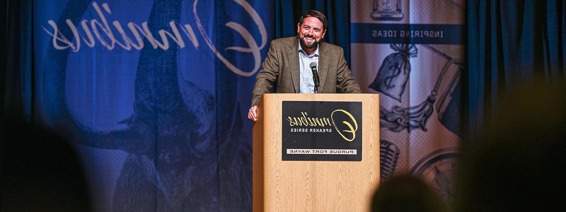 Luke Russert presents behind podium at Omnibus Speaker Series